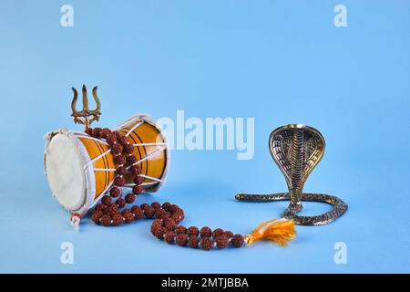 Shivarcomed-Hintergrund mit Shivas-Dreizack, Pellet Drum Damroo-Musikinstrument und Schlange. Maha Shivratri Festtag Stockfoto