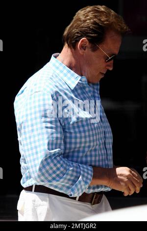 Der Schauspieler und ehemalige kalifornische Gouverneur Arnold Schwarzenegger sieht in weißen Hosen und einem blauen Karohemd gut aus, wenn er Barney's nach einem Einkaufsbummel verlässt. Los Angeles, Kalifornien. 9. Juli 2012 . Stockfoto