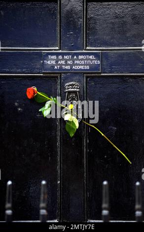 Fans haben Gedenkblumen vor dem Haus des Künstlers Sebastian Horsley platziert, wo er gestern tot aufgefunden wurde, wegen einer vermuteten Überdosis Heroin. Das Haus hat auch ein seltsames Schild an der Tür, auf dem steht "Dies ist kein Bordell. Hier gibt es keine Prostituierten." Die Leiche von Horsley, 47, die einst im Namen der Kunst gekreuzigt wurde, wurde von einer Freundin gefunden. Sein Tod kommt nur wenige Tage nach einem Stück „Dandy in the Underworld“, das auf seinen eigenen Memoiren basiert und im Soho Theatre eröffnet wurde. London, Großbritannien. 6/18/10. Stockfoto