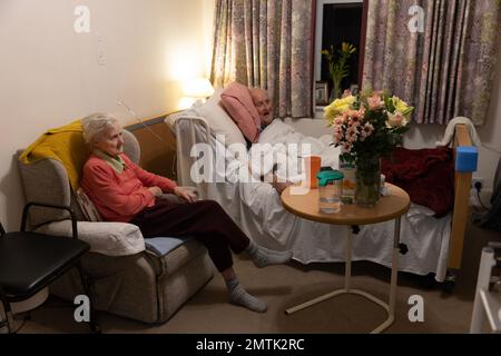 Ältere Ehepaare in den 80ern zusammen in einem Pflegeheim-Schlafzimmer in England, Großbritannien Stockfoto