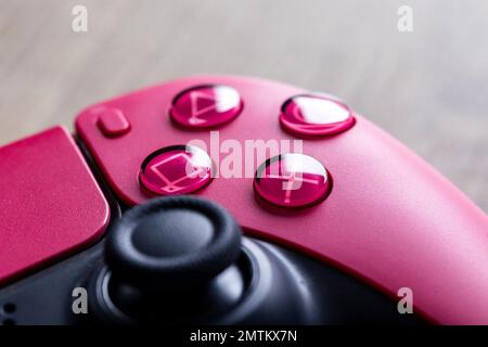 Brecht, Belgien - 26 januari 2023: Nahaufnahme der klassischen Tasten eines kosmischen roten sony playstation 5 Wireless-Controllers. Das Dreieck, CI Stockfoto