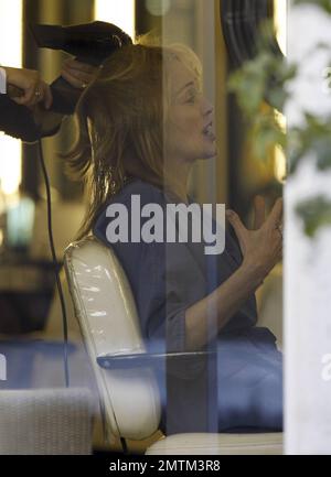 Sharon Stone lacht mit ihrer Stylist, während sie sich in einem Friseursalon in Beverly Hills, Kalifornien, frisieren lässt. 1/31/11. Stockfoto