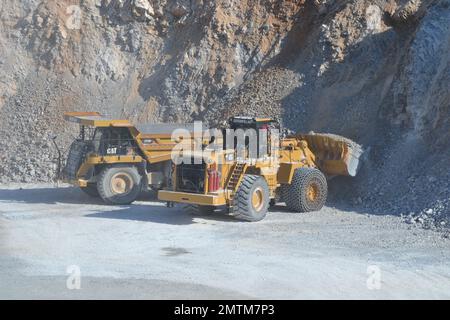 Radlader beladen den Kipper mit Kalkstein. Arbeiten in einem Kalksteinbruch. Stockfoto