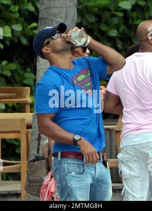 Schauspieler Shemar Moore trägt ein Superman-T-Shirt bei einem Strandspaziergang. Moore trug eine Flasche Bräunungsöl in seiner Tasche und hatte etwas, das wie eine große nasse Stelle im Schritt seiner Jeans aussah. Moore unterhielt sich auch mit Freunden am Pool, die eine Flasche Tequila hielten, von der er vorgab, während er plauderte. Miami Beach, Florida 7. Mai 2012 Stockfoto