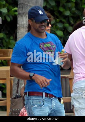 Schauspieler Shemar Moore trägt ein Superman-T-Shirt bei einem Strandspaziergang. Moore trug eine Flasche Bräunungsöl in seiner Tasche und hatte etwas, das wie eine große nasse Stelle im Schritt seiner Jeans aussah. Moore unterhielt sich auch mit Freunden am Pool, die eine Flasche Tequila hielten, von der er vorgab, während er plauderte. Miami Beach, Florida 7. Mai 2012 Stockfoto