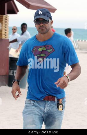 Schauspieler Shemar Moore trägt ein Superman-T-Shirt bei einem Strandspaziergang. Moore trug eine Flasche Bräunungsöl in seiner Tasche und hatte etwas, das wie eine große nasse Stelle im Schritt seiner Jeans aussah. Moore unterhielt sich auch mit Freunden am Pool, die eine Flasche Tequila hielten, von der er vorgab, während er plauderte. Miami Beach, Florida 7. Mai 2012 Stockfoto