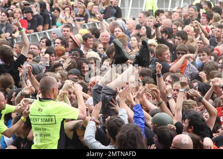 Konzertbesucher surfen, während die walisische Rock Reggae Metal Band Skindred live beim Sonisphere Festival auftritt, einem Musikevent für Rock, Metal, Electro und Punk im Knebworth House and Park. Knebworth, Großbritannien. 08/01/10. . Stockfoto