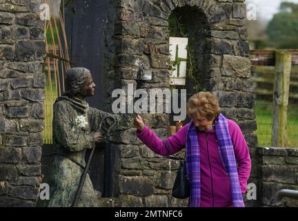 Eine Frau berührt eine Statue von St. Brigid in St. Brigids heiligem Brunnen in Co Kildare. Am 1. Februar findet der St. Brigid's Day statt, der von vielen in Irland als erster Frühlingstag angesehen wird. Bilddatum: Mittwoch, 1. Februar 2023. Stockfoto