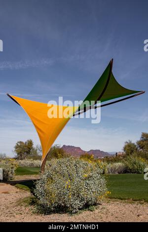 Golfplatz mit großem Sonnenschirm in der Wüste vor blauem Himmel Stockfoto