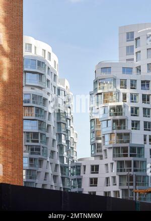 Rotes Ziegelwerk, das an die weiße gewellte Fassade des Prospect Place gekoppelt ist. Prospect Place Battersea Power Station Frank Gehry, London, Vereinigtes Königreich. Archit Stockfoto