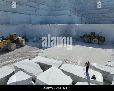 Radlader, die an riesigen Marmorsteinbrüchen arbeiten. Stockfoto