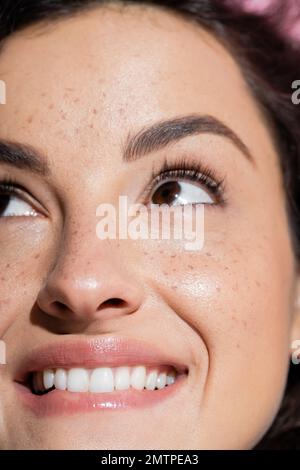 Zugeschnittener Blick auf eine träumige und Sommersprossen-Frau, die aufblickt, Stockbild Stockfoto