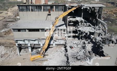 Hydraulikbagger mit Hydraulikhammer zum Abriss eines Industriegebäudes. Stockfoto