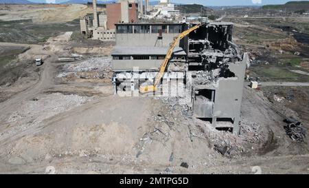 Hydraulikbagger mit Hydraulikhammer zum Abriss eines Industriegebäudes. Stockfoto