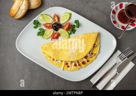 Omelett mit Fetakäse und türkischer Wurst auf einer weißen Porzellanplatte Stockfoto