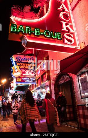 Nashville, Tennesee - 21. Januar 2023: Straßenszene des berühmten Lower Broadway in Nashville, Tennessee, bei Nacht mit Lichtern und historischem Honky-to Stockfoto