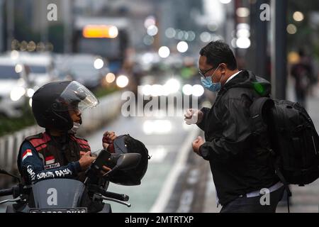 Jakarta, Indonesien. 1. Februar 2023. Ein Mann, der eine Fahrt braucht, spricht mit einem Taxifahrer auf dem Bürgersteig der Thamrin Street in Jakarta, Indonesien, am 1. Februar 2023. Indonesien verzeichnete im Januar gegenüber dem Vorjahr eine Inflation von 5,28 Prozent, die niedrigste seit August 2022, aber sie übertraf nach Angaben der Statistikbehörde Indonesien BPS am Mittwoch immer noch das Ziel der Zentralbank. Kredit: Veri Sanovri/Xinhua/Alamy Live News Stockfoto