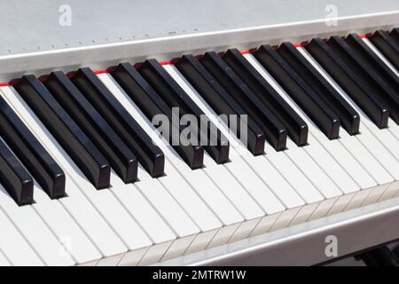 Nahaufnahme der Klaviertasten. Schließen Sie die Frontalansicht mit schwarzen und weißen Pianotasten, von oben gesehen. Stockfoto