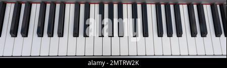 Nahaufnahme der Klaviertasten. Schließen Sie die Frontalansicht mit schwarzen und weißen Pianotasten, von oben gesehen. Stockfoto