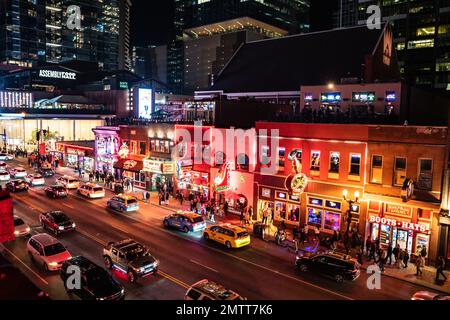 Nashville, Tennesee - 21. Januar 2023: Straßenszene des berühmten Lower Broadway in Nashville, Tennessee, bei Nacht mit Lichtern und historischem Honky-to Stockfoto