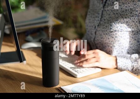 Elektronischer Luftbefeuchter auf dem Schreibtisch eines Büromitarbeiters Stockfoto