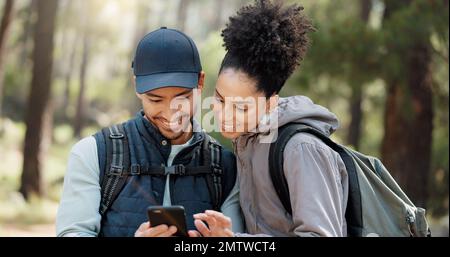 Wandern, Smartphone und Reisepaar mit Standortsuche, Online-Reiseführer oder Naturreiseplanung zusammen in einem Wald auf 5G Netzwerk. Rucksack Stockfoto