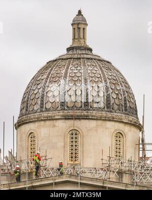 London, Großbritannien. 01. Februar 2023. Baumeister in Schutzhelmen und Sicherheitswesten sind heute auf dem oberen Teil der Fassade der National Gallery zu sehen. Das Museum, das 1838 am Trafalgar Square eröffnet wurde, wird im Jahr 2024 zum Zweiten Mal eröffnet und wird derzeit im Rahmen des Programms NG200 umfassend renoviert und renoviert. Große Teile der Fassade gegenüber dem Trafalgar Square sind mit Gerüsten bedeckt. Kredit: Imageplotter/Alamy Live News Stockfoto