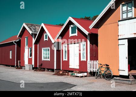 Farbenfrohe traditionelle Fischerhütten, Bootshäuser in Reihe, kleiner Hafen. Stauraum zum Angeln oder als Ferienhaus im Sommer gemietet Stockfoto