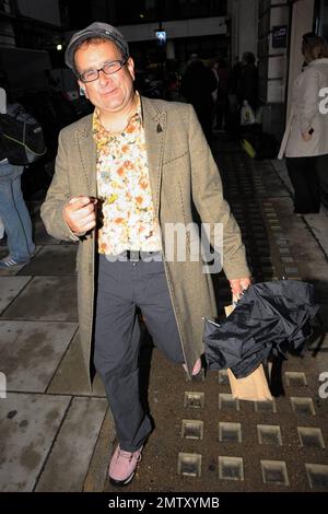 Der Fernsehmoderator Timmy Mallett aus den 80s und 90s Jahren lächelt, wenn er BBC Radio 2 verlässt. Er trägt ein ansprechendes Outfit, bestehend aus einem vielseitig gemusterten Hemd mit orangefarbenem und gelbem Blumenmuster, gestreiften Hosen und pinkfarbenen Schuhen. London, Großbritannien. 11/5/10. Stockfoto