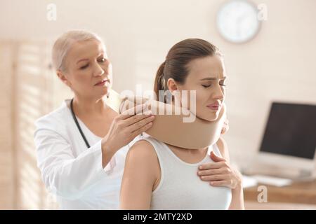 Orthopädin in der Klinik mit Halskragen am Hals des Patienten Stockfoto