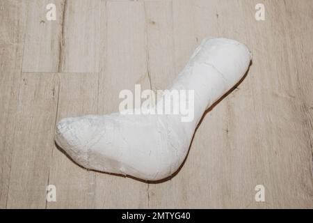 Der vom Bein entfernte Gips liegt als Symbol auf dem Boden, dass der Patient geheilt ist Stockfoto