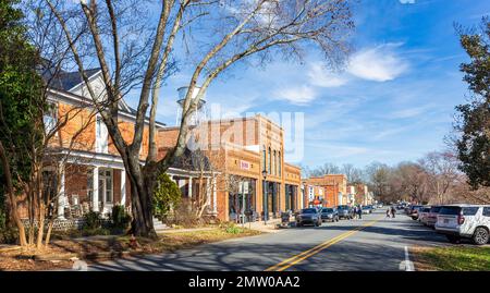 WAXHAW, NC, USA-28. JANUAR 2023: Weitwinkelblick auf N. Main Street an einem geschäftigen Samstag. Sonnig mit blauem Himmel. Leute, die die Straße überqueren. Stockfoto