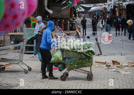 Ein palästinensischer Arbeiter schiebt einen Transportwagen mitten auf der Straße im Flüchtlingslager Jabalia während des schlechten Wetters in Gaza, 1. Februar 2023. Foto: Ramez Habboub/ABACAPRESS.COM Stockfoto