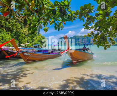 Thailändische traditionelle hölzerne Langboote parken am tropischen Railay Beach in Thailand, Provinz Krabi. Die einzige Art von Transport, um den Strand zu erreichen Stockfoto