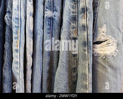 Nahaufnahme von Used Blue Jeans mit ausgefranstem Loch Stockfoto