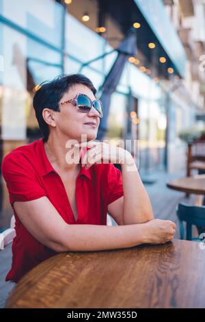 Porträt einer attraktiven, reifen Frau mit Brille im Café Stockfoto