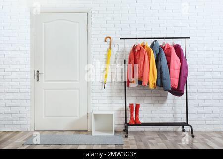 Gestell mit stilvollen warmen Jacken im Flur Stockfoto