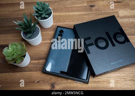 Brandneues Samsung Galaxy Z Fold 4 in grau-grüner Farbe. Das Gerät befindet sich in der geöffneten Position. Stockfoto