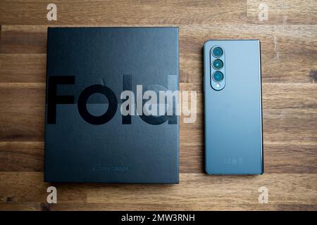 Brandneues Samsung Galaxy Z Fold 4 in grau-grüner Farbe. Das Gerät befindet sich in der geschlossenen Position. Stockfoto