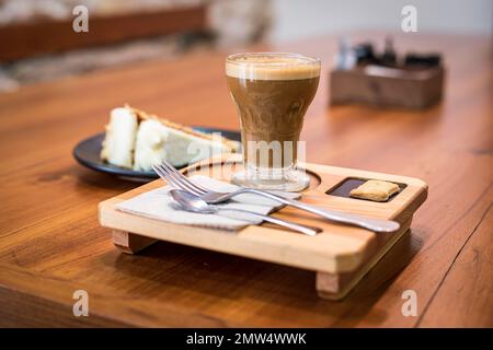 Kaffeeerlebnis Stillleben mit Latte und Karottenkuchen auf einem gut beleuchteten Kaffeetisch Stockfoto