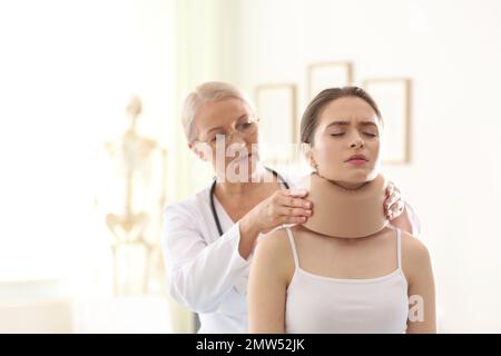 Orthopädin in der Klinik mit Halskragen am Hals des Patienten Stockfoto