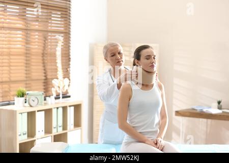 Orthopädin in der Klinik mit Halskragen am Hals des Patienten Stockfoto