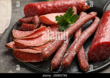 Verschiedene leckere Würstchen auf grauem Tisch, Nahaufnahme Stockfoto