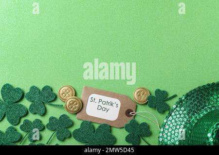 Kleeblätter und Anhänger mit der Phrase St. Patrick's Day auf hellgrünem Hintergrund, flach liegend. Platz für Text Stockfoto