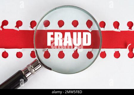 Zwischen zwei Blättern aus einem Notizbuch auf einem roten Streifen mit der Inschrift - Betrug - befindet sich eine Lupe. Stockfoto