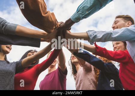 Eine Gruppe unterschiedlicher junger Menschen unterschiedlicher ethnischer Herkunft kommt zusammen, um Einheit und Freundschaft zu symbolisieren. Eine multirassische Gruppe von Freunden aus Differeren Stockfoto