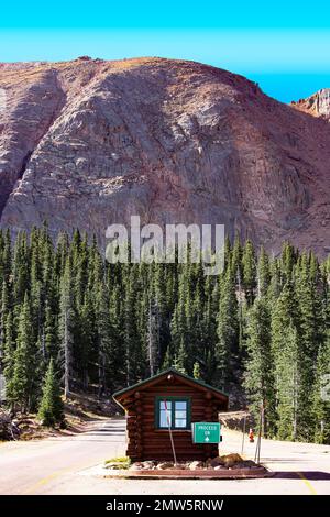 Eine vertikale Aufnahme einer Ranger-Station im Hintergrund des Gipfels des Pikes Peak in Colorado Stockfoto