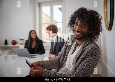 Eine Gruppe junger Geschäftsleute während eines Treffens, Nahaufnahme eines lächelnden jungen afrikanischen Unternehmertums Stockfoto