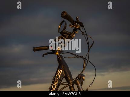 Heubälle und Elektrofahrrad auf dem Feld bei Ceske Budejovice Stadt in Sonnenaufgang Zeit in Farbe Herbst Stockfoto