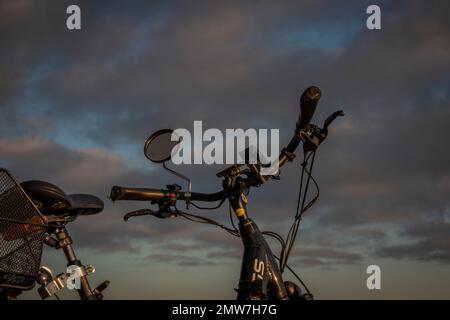 Heubälle und Elektrofahrrad auf dem Feld bei Ceske Budejovice Stadt in Sonnenaufgang Zeit in Farbe Herbst Stockfoto